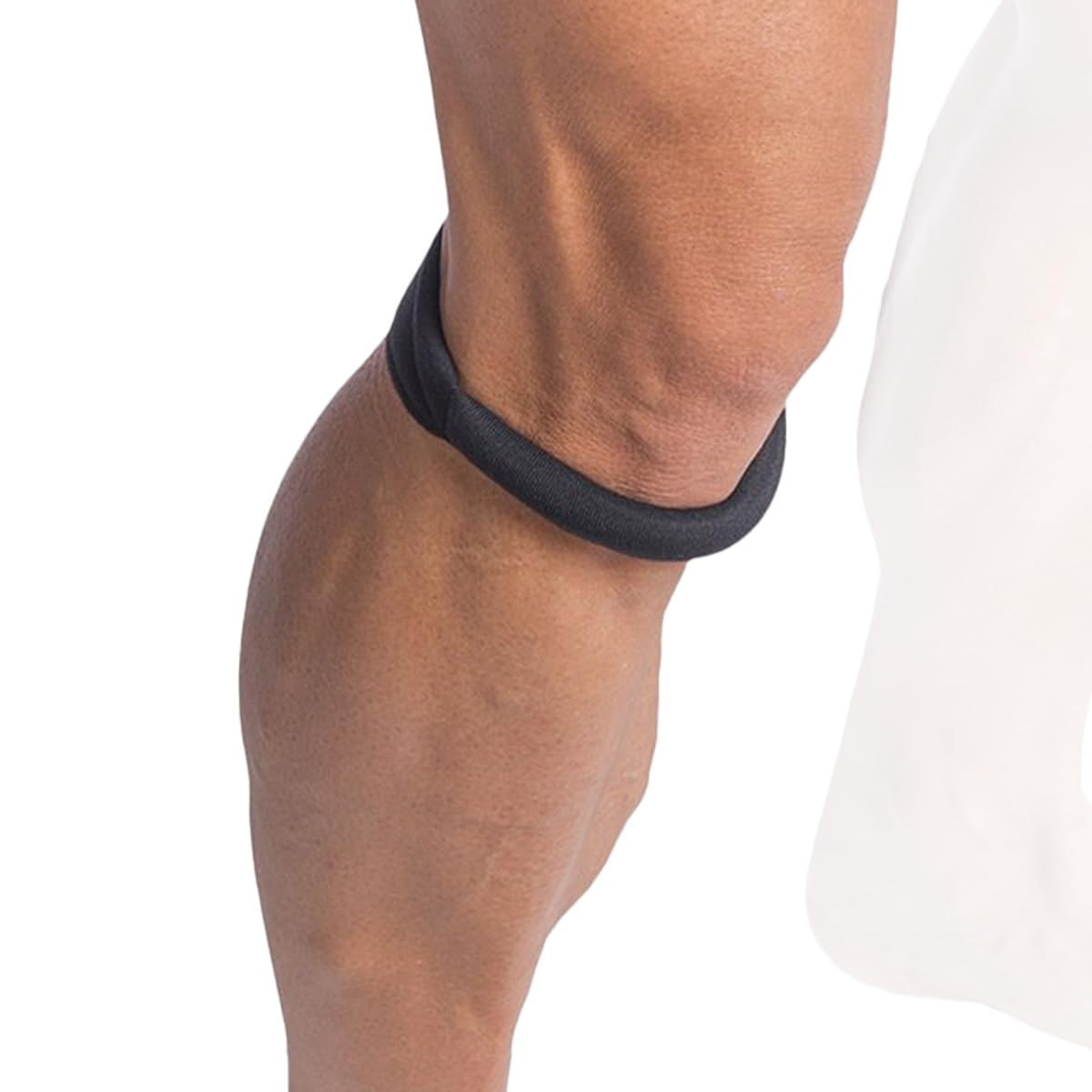 Black knee brace on a person's knee with a white background