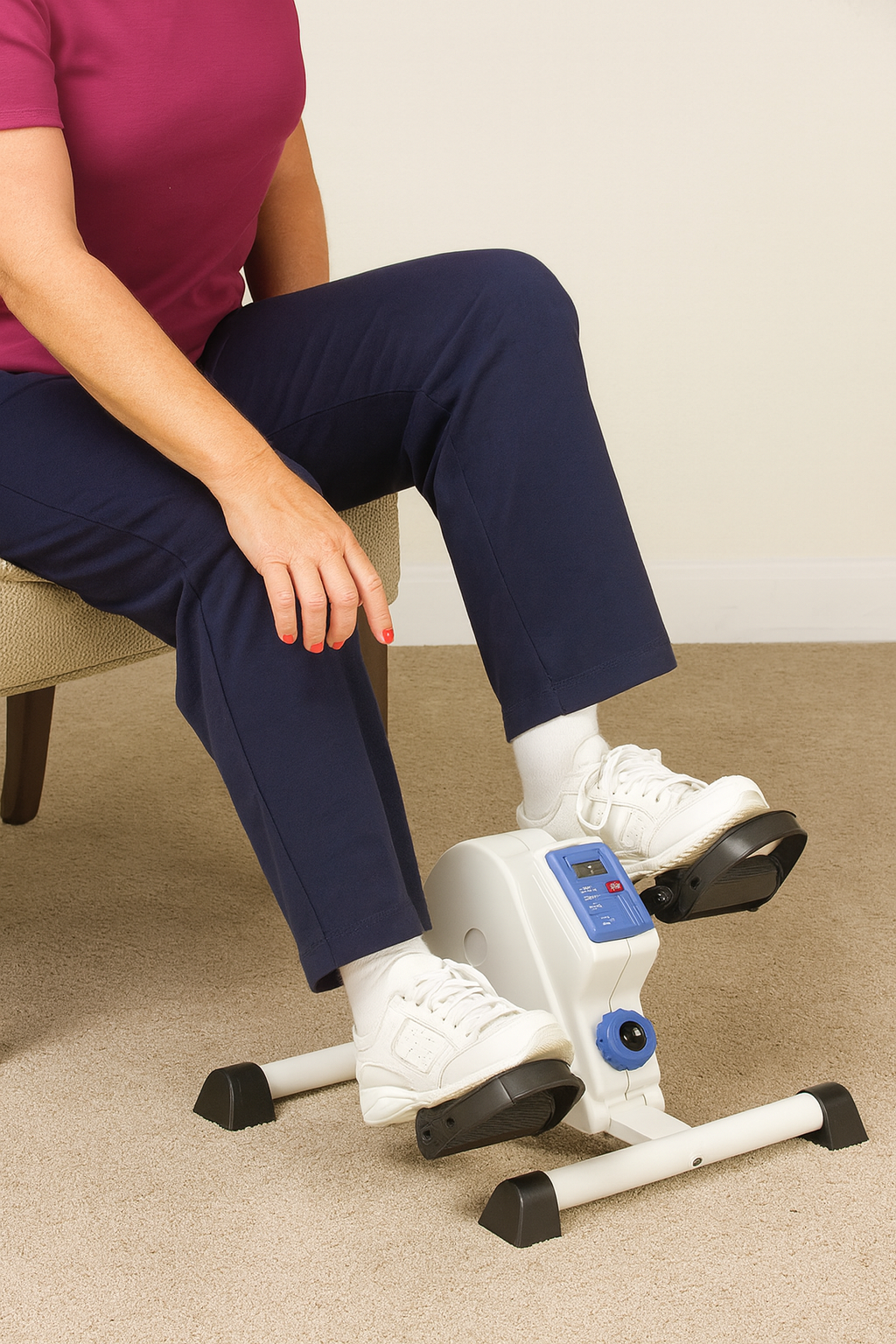 Person using a small exercise bike on a carpeted floor.