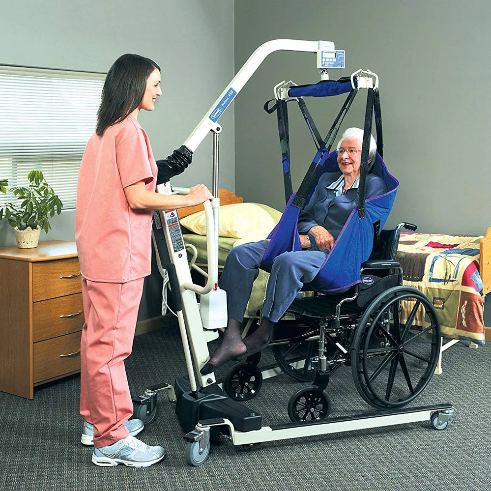Person using a medical lift to assist an elderly person in a wheelchair.